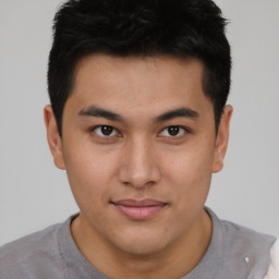 Joyful asian young-adult male with short  brown hair and brown eyes