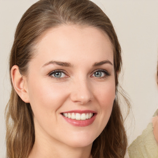 Joyful white young-adult female with long  brown hair and blue eyes