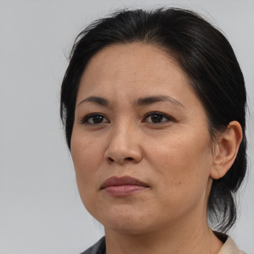 Joyful asian adult female with medium  brown hair and brown eyes