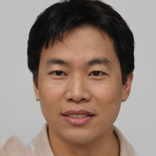Joyful asian young-adult male with short  black hair and brown eyes