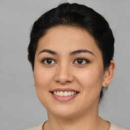 Joyful latino young-adult female with medium  brown hair and brown eyes