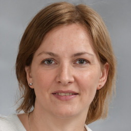 Joyful white adult female with medium  brown hair and blue eyes