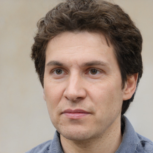 Joyful white adult male with short  brown hair and grey eyes