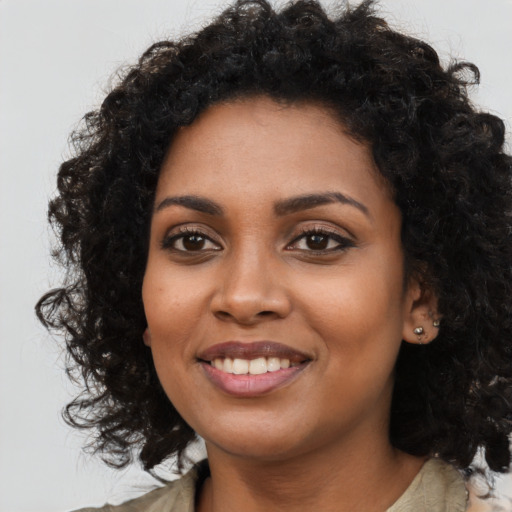 Joyful black young-adult female with long  black hair and brown eyes