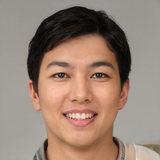 Joyful asian young-adult male with short  black hair and brown eyes