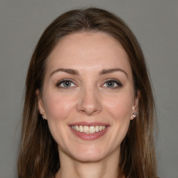 Joyful white young-adult female with long  brown hair and grey eyes