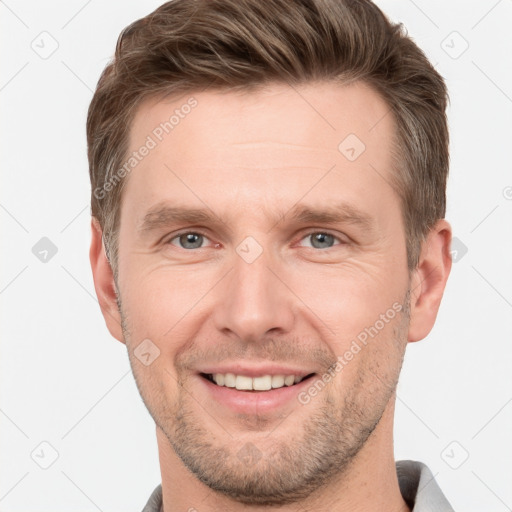 Joyful white young-adult male with short  brown hair and grey eyes