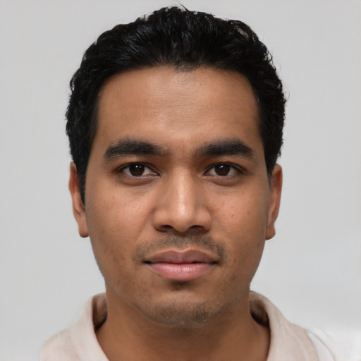 Joyful latino young-adult male with short  black hair and brown eyes