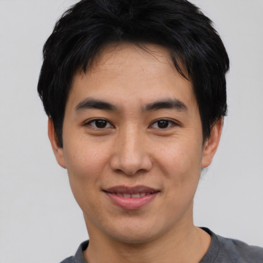 Joyful asian young-adult male with short  black hair and brown eyes