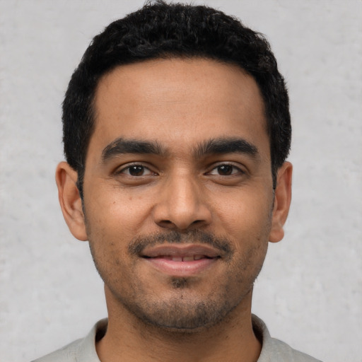 Joyful latino young-adult male with short  black hair and brown eyes