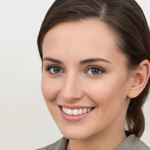 Joyful white young-adult female with medium  brown hair and grey eyes