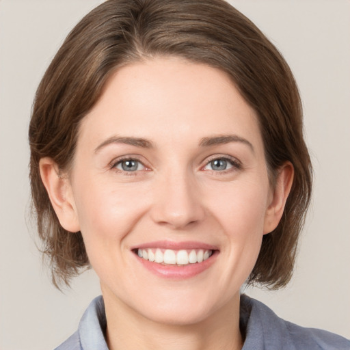 Joyful white young-adult female with medium  brown hair and grey eyes