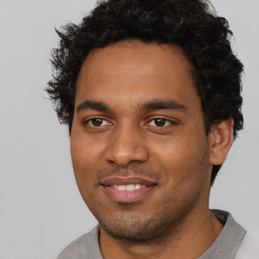 Joyful black young-adult male with short  black hair and brown eyes