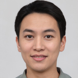 Joyful asian young-adult male with short  black hair and brown eyes