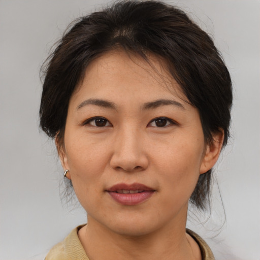 Joyful asian adult female with medium  brown hair and brown eyes