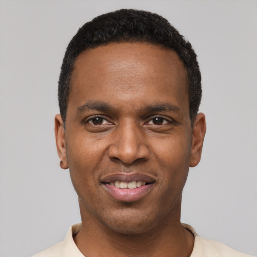 Joyful black young-adult male with short  black hair and brown eyes