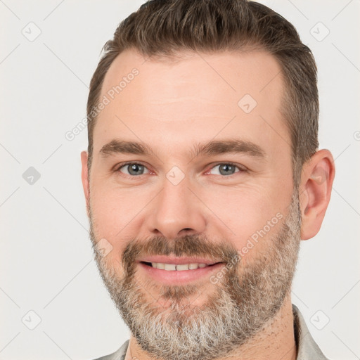 Joyful white adult male with short  brown hair and brown eyes