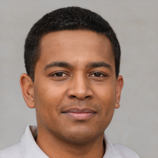 Joyful black young-adult male with short  brown hair and brown eyes