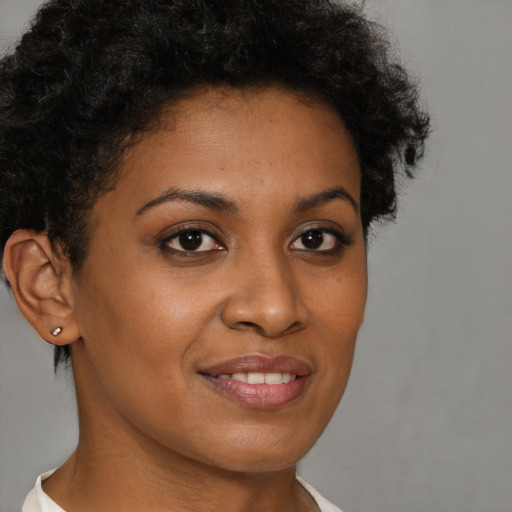 Joyful black young-adult female with short  brown hair and brown eyes