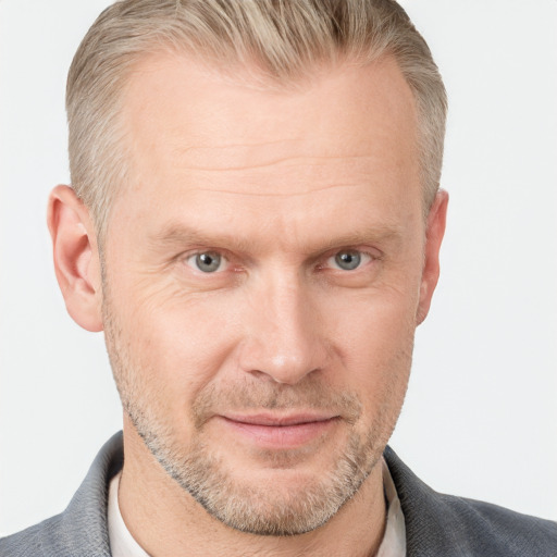 Joyful white adult male with short  brown hair and blue eyes