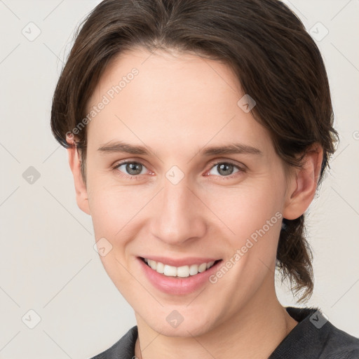 Joyful white young-adult female with medium  brown hair and grey eyes