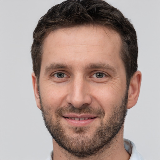 Joyful white adult male with short  brown hair and brown eyes