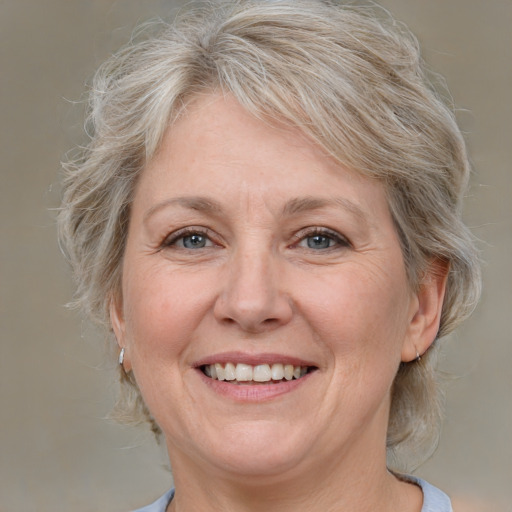 Joyful white middle-aged female with medium  blond hair and grey eyes