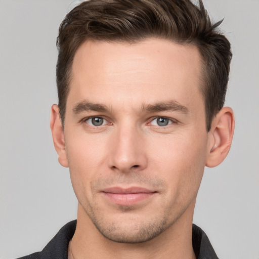 Joyful white young-adult male with short  brown hair and grey eyes