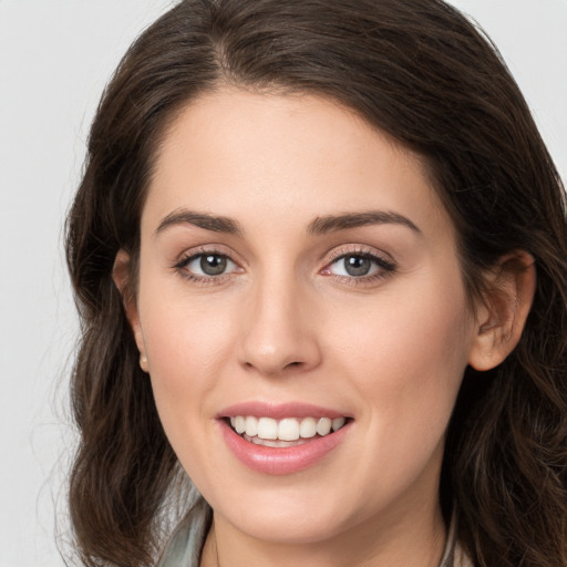 Joyful white young-adult female with long  brown hair and grey eyes