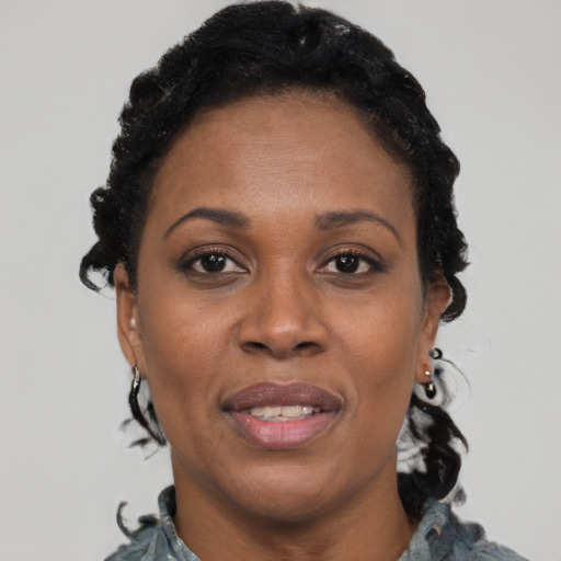 Joyful black adult female with short  black hair and brown eyes