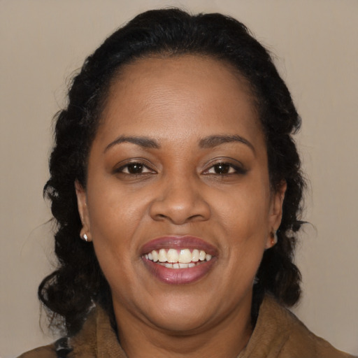 Joyful black adult female with medium  brown hair and brown eyes
