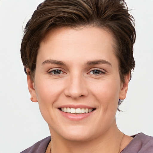 Joyful white young-adult female with short  brown hair and grey eyes