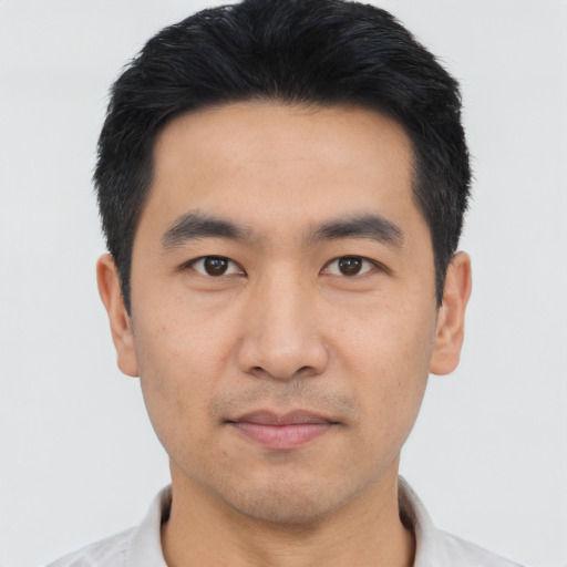 Joyful asian young-adult male with short  black hair and brown eyes