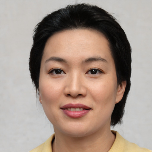 Joyful asian young-adult female with medium  black hair and brown eyes