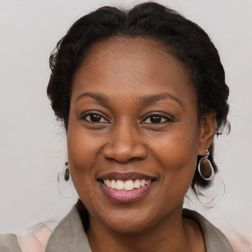 Joyful black adult female with long  brown hair and brown eyes