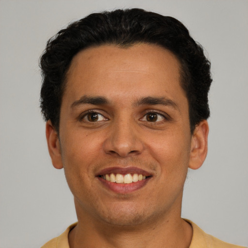 Joyful latino young-adult male with short  brown hair and brown eyes