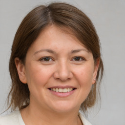 Joyful white adult female with medium  brown hair and brown eyes