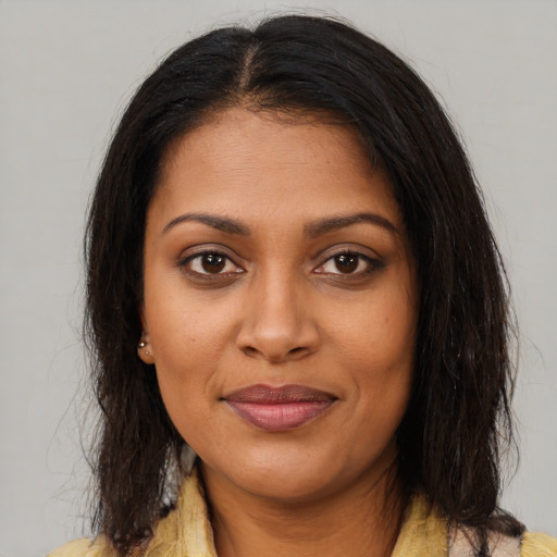 Joyful black young-adult female with medium  brown hair and brown eyes