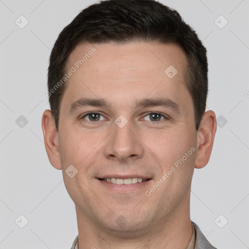 Joyful white young-adult male with short  brown hair and grey eyes