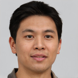 Joyful asian adult male with short  brown hair and brown eyes