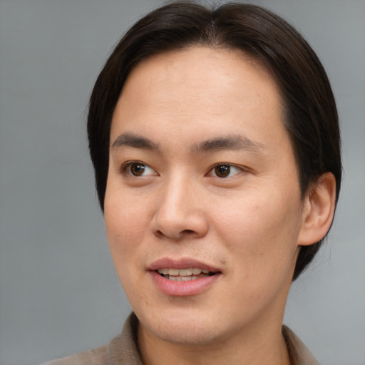 Joyful asian young-adult male with short  brown hair and brown eyes