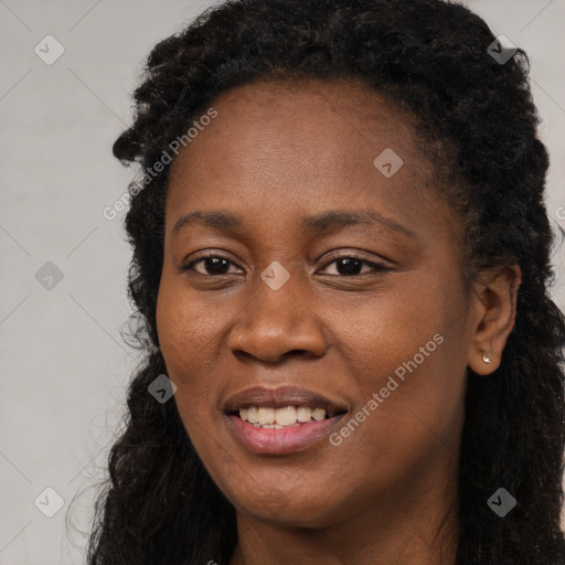 Joyful black young-adult female with long  black hair and brown eyes