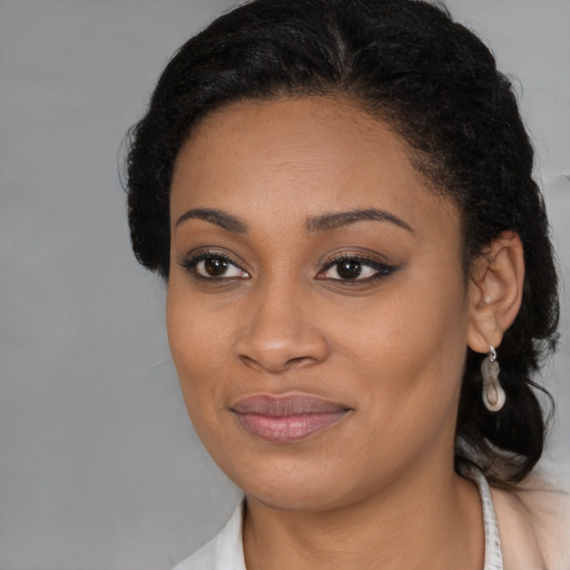 Joyful black young-adult female with long  brown hair and brown eyes