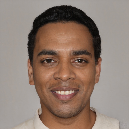 Joyful black young-adult male with short  black hair and brown eyes