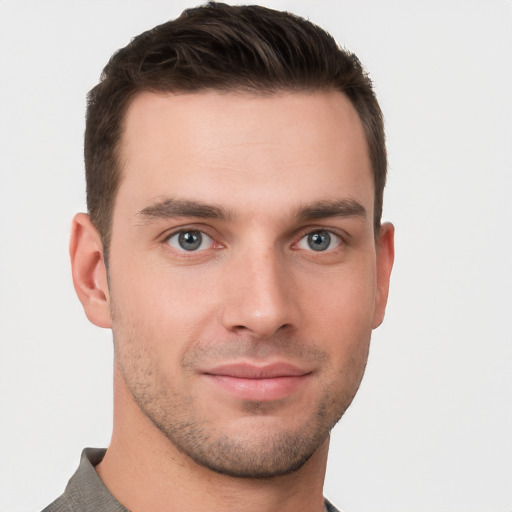 Joyful white young-adult male with short  brown hair and grey eyes