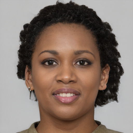 Joyful black young-adult female with short  brown hair and brown eyes