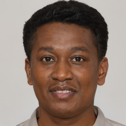 Joyful black young-adult male with short  black hair and brown eyes