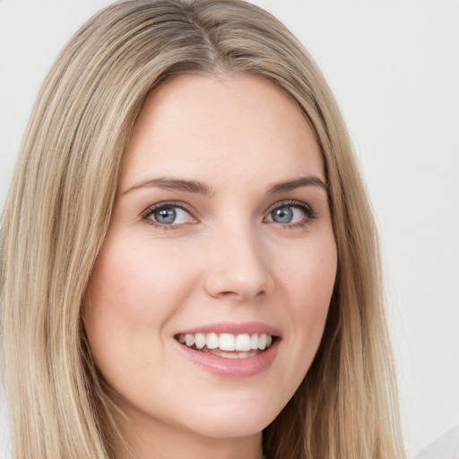 Joyful white young-adult female with long  brown hair and blue eyes