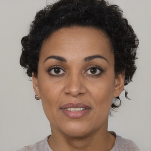 Joyful black young-adult female with short  brown hair and brown eyes