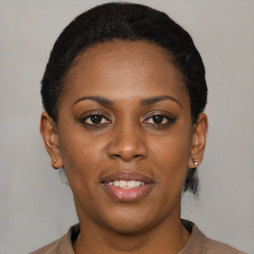 Joyful black young-adult female with short  black hair and brown eyes